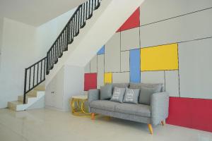 a living room with a chair and a colorful wall at Ndalem Kraton Hotel in Sidoarjo