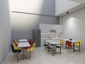 a room with tables and chairs and a kitchen at Ndalem Kraton Hotel in Sidoarjo