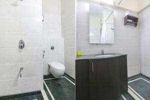 bagno con lavandino, servizi igienici e specchio di FabHotel Radiant Inn DLF Phase 3 a Gurgaon