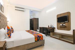 Schlafzimmer mit einem Bett, einem Schreibtisch und einem TV in der Unterkunft FabHotel Radiant Inn DLF Phase 3 in Gurgaon