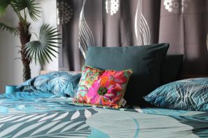 a bed with a colorful pillow on top of it at HIME LODGE in Papeete
