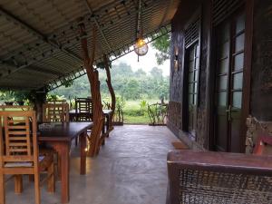 a porch of a restaurant with tables and chairs at Ceylon Resort Wilpattu in Wilpattu
