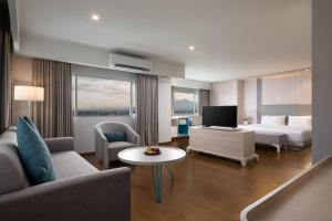 a hotel room with a bed and a tv at Hotel Santika Bogor in Bogor