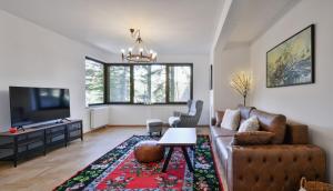 a living room with a couch and a tv at Bellevue Bjelasnica in Bjelašnica