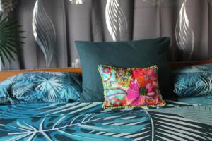 a bed with colorful pillows on top of it at HIME LODGE in Papeete