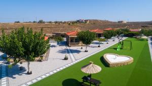 een uitzicht op een speeltuin met groen gras bij Aphrodite Stone Apartments in Moúdhros