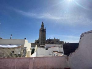 a tall building with a clock tower in the background at acogedor apartamento placentines in Seville