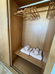 2 ręczniki znajdują się w drewnianej szafie. w obiekcie Pearl Apartment Corralejo w Corralejo