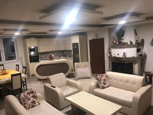 a living room with white furniture and a kitchen at LUX Villa Mavrovo in Mavrovo