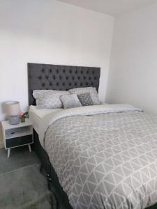 a bedroom with a large bed with a gray headboard at Remarkable and modern house in Rugby England in Rugby