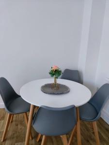 a white table with four chairs and a vase with flowers at Remarkable and modern house in Rugby England in Rugby