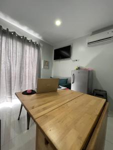 a kitchen with a wooden table with a laptop on it at The Linds Condo Unit 814 Cityscape in Bacolod