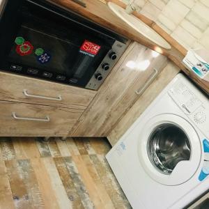 uma máquina de lavar e secar roupa numa cozinha com um balcão em Квартира в стиле лофт em Karaganda