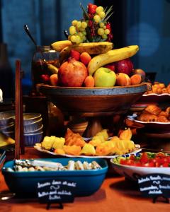 einen Tisch mit einer Schale Obst und Teller mit Speisen in der Unterkunft Hotel de Nell in Paris