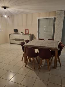 una mesa de comedor y sillas en una habitación en Au cocon de Lin, en Le Neubourg