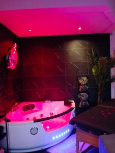 a pink bath tub in a room with a table at ESCAPADE en CHAMPAGNE Moments conviviaux entre amis, famille in Épernay +143 photos