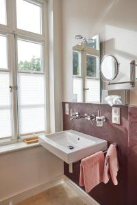 a bathroom with a sink and a mirror at Hotel Cramer Bed & Breakfast in Werlte