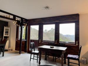 a dining room with a table and chairs and windows at Haus Balke in Hatzfeld