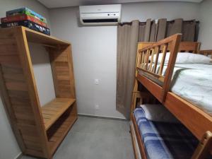 two bunk beds in a room with a bed and a fan at Apartamento Paz e Traquilidade na praia in Luis Correia