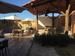 a wooden deck with tables and chairs and umbrellas at Apartamento Paz e Traquilidade na praia in Luis Correia