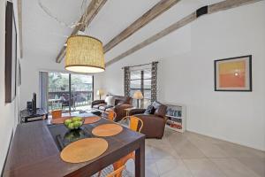 a kitchen and living room with a table and chairs at Inviting condo with pool just a steps from the beach in Marco Island