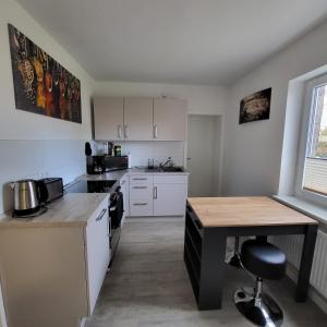 a kitchen with white cabinets and a wooden table at Ferienwohnung NR3 in Großräschen