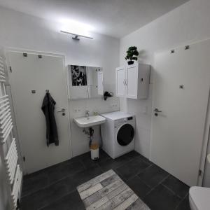 a white bathroom with a sink and a toilet at Ferienwohnung NR3 in Großräschen