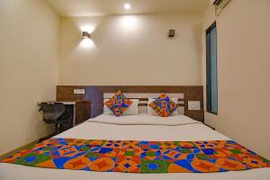 Un dormitorio con una cama con una colcha colorida. en FabHotel Royce Studio Apartments en Pune