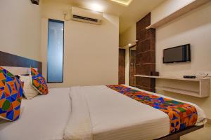 1 dormitorio con 1 cama grande y TV en FabHotel Royce Studio Apartments en Pune