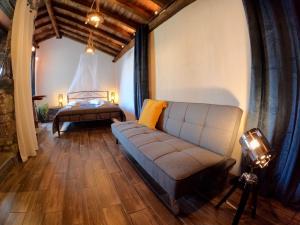 a living room with a couch and a bed at FoRest Loft in Tsagarada