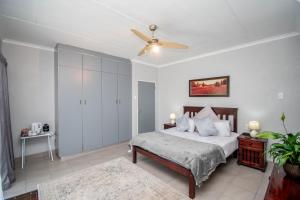 a bedroom with a bed and a ceiling fan at Nita's Air Bed & Breakfast & self catering in Crocodile Valley Estates