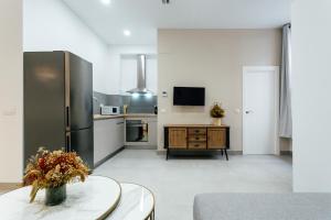 uma cozinha com um frigorífico e uma mesa num quarto em Tu casa en un rinconcito del centro em Sevilha