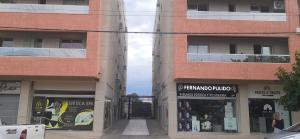 un par de edificios altos con tiendas en ellos en Paz Apartments en San Juan