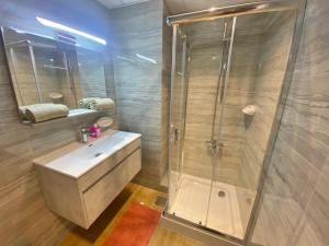 ein Bad mit einer Dusche und einem Waschbecken in der Unterkunft Manchester Galaxy - 2BR Apartment in Dubai Marina in Dubai