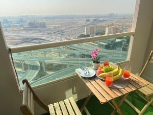 a table with fruit and drinks on a balcony with a view at Manchester Galaxy - 2BR Apartment in Dubai Marina in Dubai