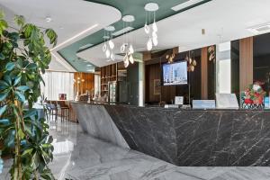 a bar in a hotel lobby with a counter at Hotel Bracera in Budva