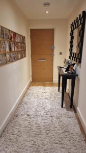 a hallway with a table and a door at Beautiful and modern Apartment in North London in Hendon
