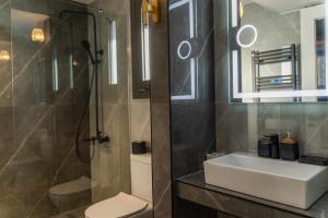 a bathroom with a sink and a shower and a toilet at AN&VI Boutique Apartments Apt201 in Ioannina
