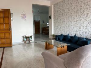 sala de estar con sofá azul y mesa en Annjal by ganga kripa en Rishīkesh