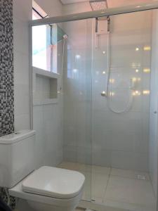 y baño blanco con ducha y aseo. en Apartamento Completo com Hidro, en Penha