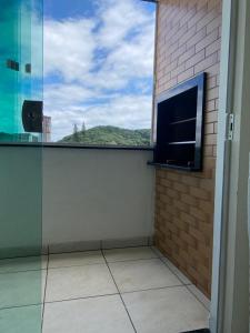 balcón con ventana y vistas a la montaña en Apartamento Completo com Hidro, en Penha