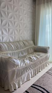 Sofá blanco en una habitación con ventana en Apartamento Completo com Hidro, en Penha