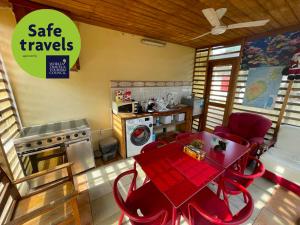 uma cozinha com uma mesa vermelha e cadeiras vermelhas num quarto em RALUX house em São Tomé