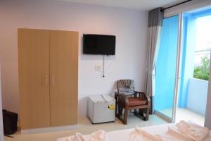 a bedroom with a cabinet and a tv and a chair at zzeehouse in Ao Nang Beach