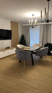 uma sala de jantar com mesa e cadeiras e uma árvore de Natal em Apartament Złoty 4 em Zblewo