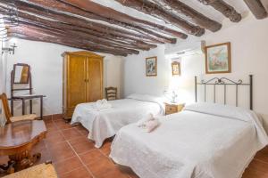 a bedroom with two beds and a table in a room at Molino de Lucero, casa rural in Teba