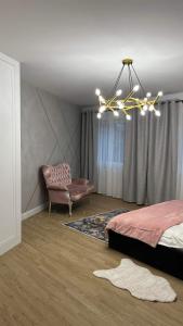 a bedroom with a bed and a chandelier at Apartament Złoty 4 in Zblewo