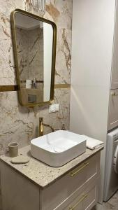 uma casa de banho com um lavatório branco e um espelho. em Apartament Złoty 4 em Zblewo