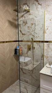 um chuveiro com uma porta de vidro na casa de banho em Apartament Złoty 4 em Zblewo