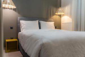 a bedroom with a large bed with white sheets and pillows at AN&VI Boutique Apartments Apt201 in Ioannina